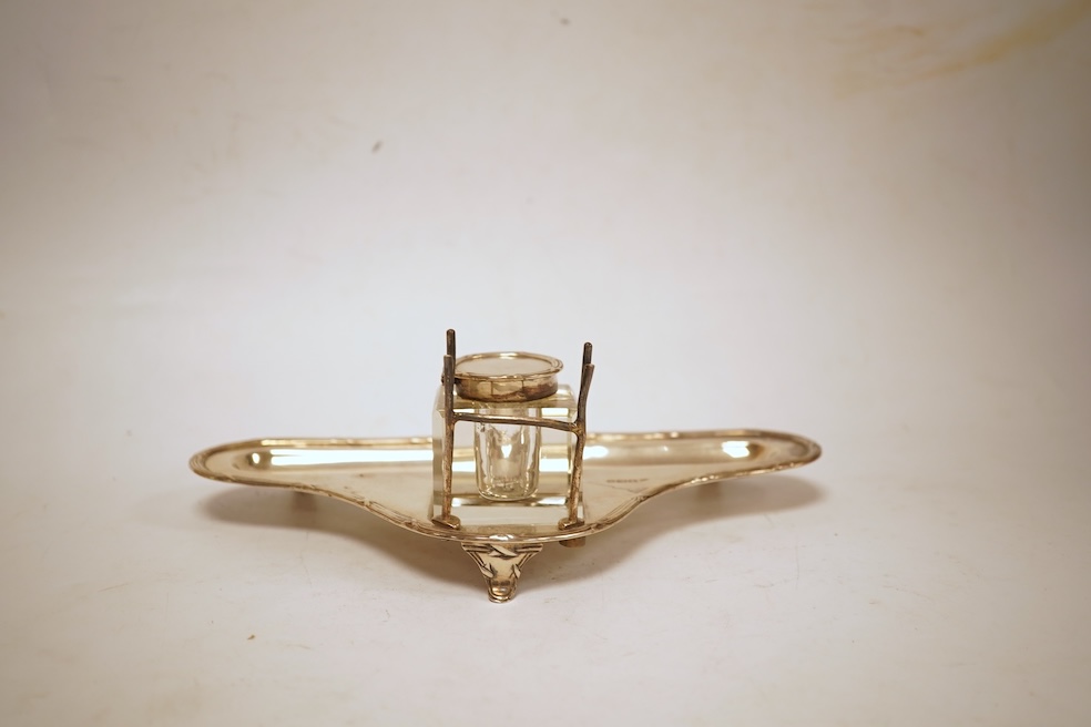 A George V silver inkstand, with single mounted glass well, pen rest and pen recess, with reeded ribbon border, William Hutton & Sons, Sheffield, 1913, 23.9cm, 5.2oz.
